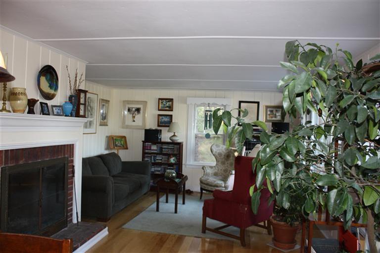 25 Crowell Road Wellfleet, MA 02667 - Photo 9 of 26 a living room with furniture a clock and a fireplace