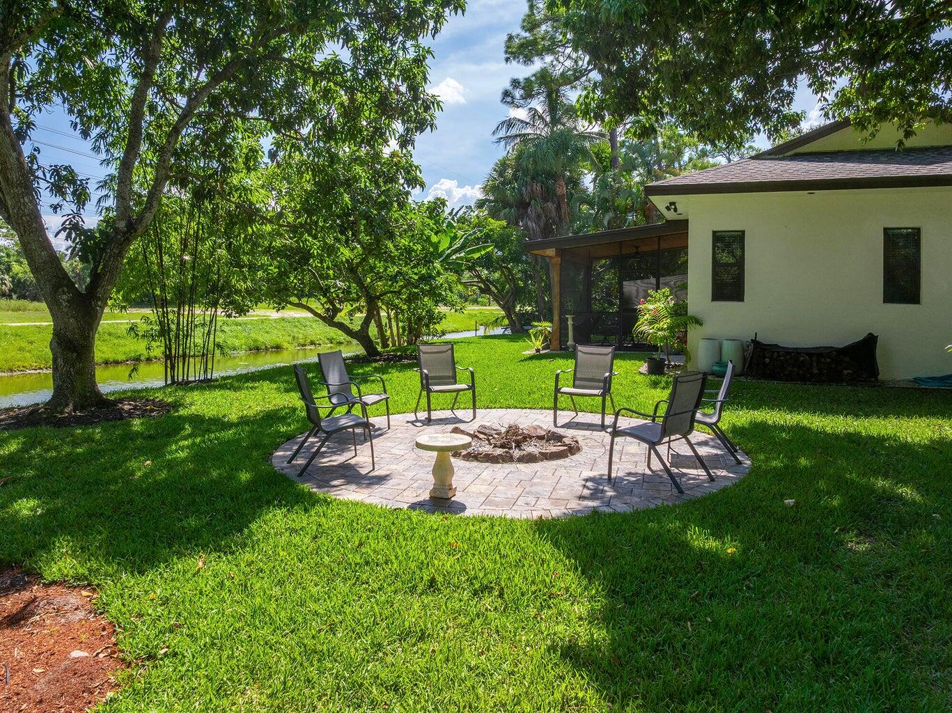 12466 Quercus Lane, Unit GUEST HOUSE Wellington, FL 33414 - Photo 20 of 24 a view of a house with backyard sitting area and garden