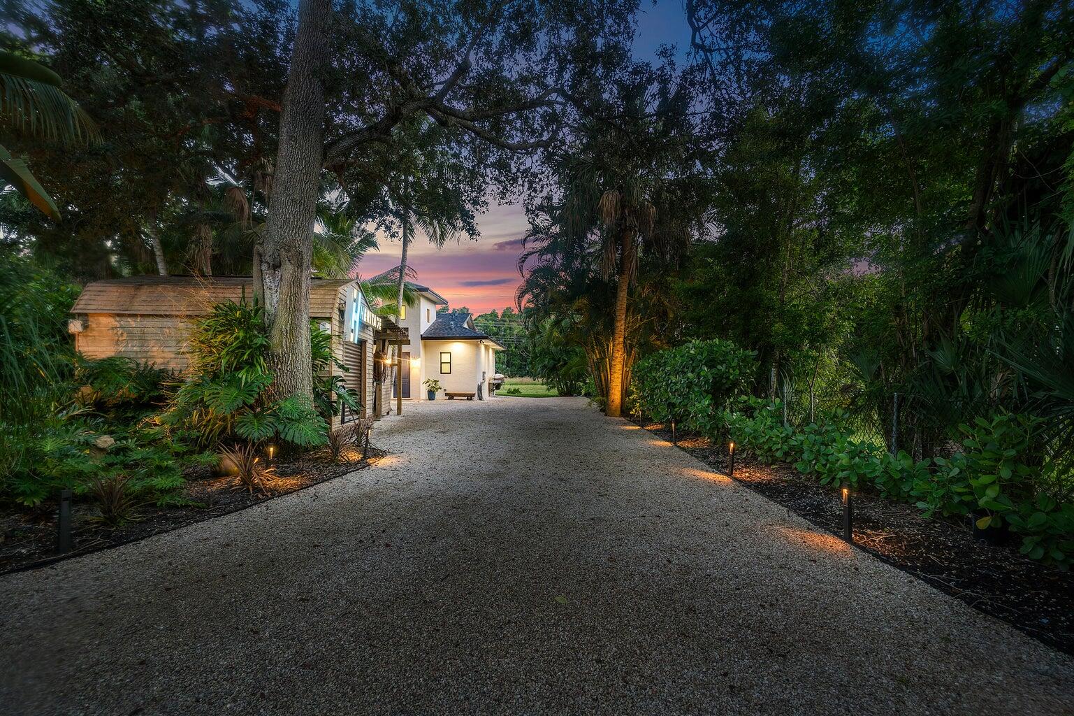 12466 Quercus Lane, Unit GUEST HOUSE Wellington, FL 33414 - Photo 22 of 24 a view of a street with a building and trees in the background
