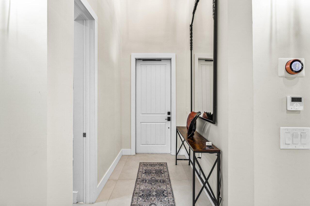 12466 Quercus Lane, Unit GUEST HOUSE Wellington, FL 33414 - Photo 3 of 24 a view of an entryway with table and mirror