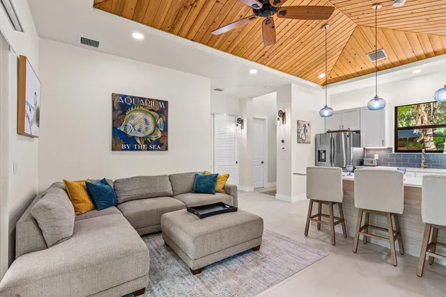 a living room with furniture a flat screen tv and a table