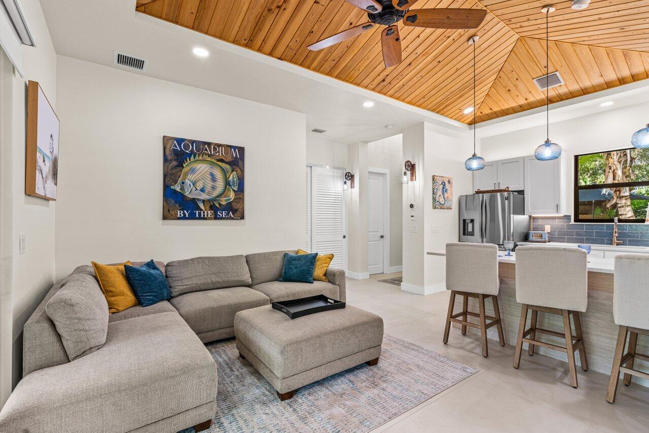 12466 Quercus Lane, Unit GUEST HOUSE Wellington, FL 33414 - Photo 7 of 24 a living room with furniture a flat screen tv and a table