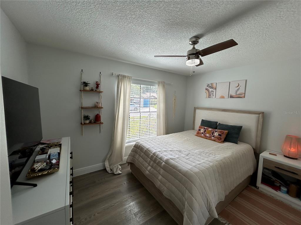 3926 Greenview Pines Court Orlando, FL 32817 - Photo 17 of 28 a bedroom with a bed and a flat tv screen on the dresser