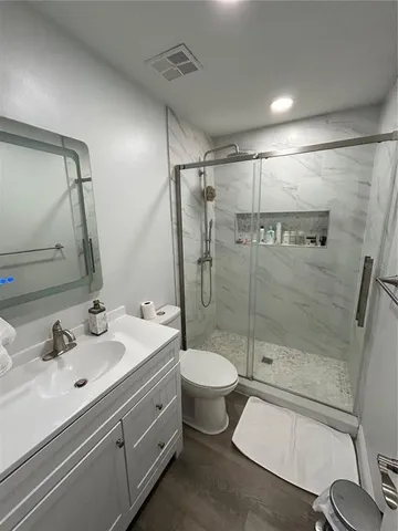 a bathroom with a double vanity sink toilet and shower