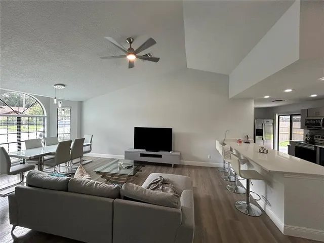 a living room with furniture and a flat screen tv with wooden floor