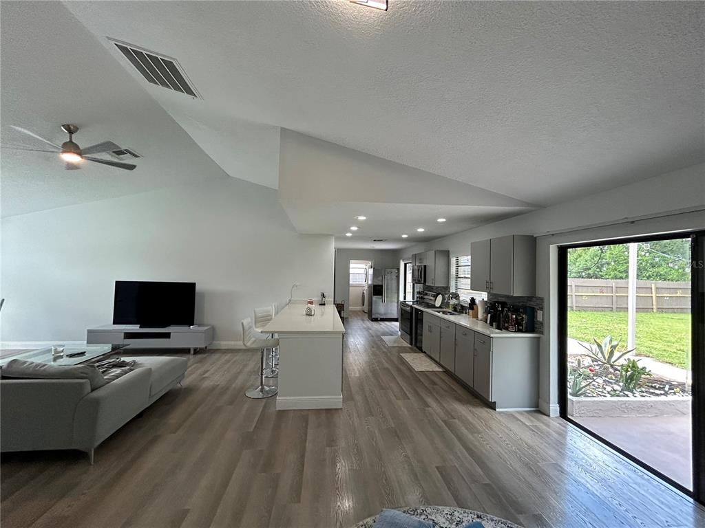 3926 Greenview Pines Court Orlando, FL 32817 - Photo 7 of 28 a living room with furniture flat screen tv and a large window