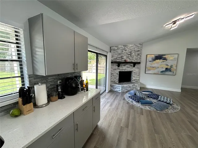 a kitchen with a refrigerator and a wooden floor