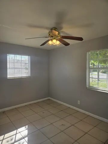 a room with chandelier fan and window