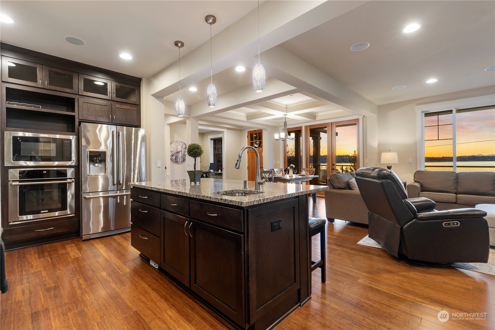 3318 Lake Washington Boulevard North Renton, WA 98056 - Photo 16 of 40 a kitchen with stainless steel appliances granite countertop a refrigerator a sink dishwasher a stove and a dining table with wooden floor