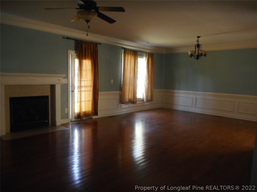 206 Blueridge Road Fayetteville, NC 28303 - Photo 2 of 16 an empty room with wooden floor fireplace and windows