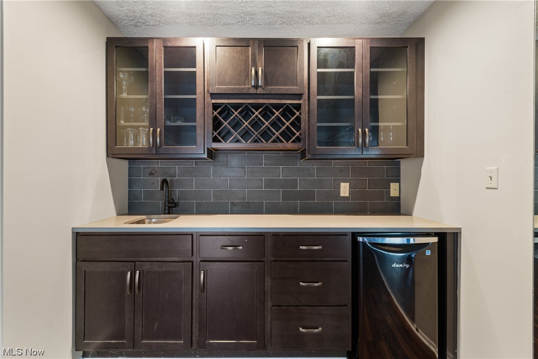949 Hampton Ridge Drive Akron, OH 44313 - Photo 11 of 35 Great use of space and updated wet bar with with new cabinets, quartz countertop, sink, backsplash, and mini-fridge.