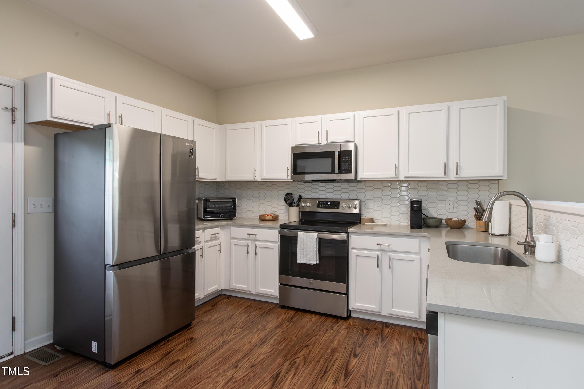 1208 Wall Street Durham, NC 27701 - Photo 6 of 16 a kitchen with stainless steel appliances a refrigerator sink and microwave