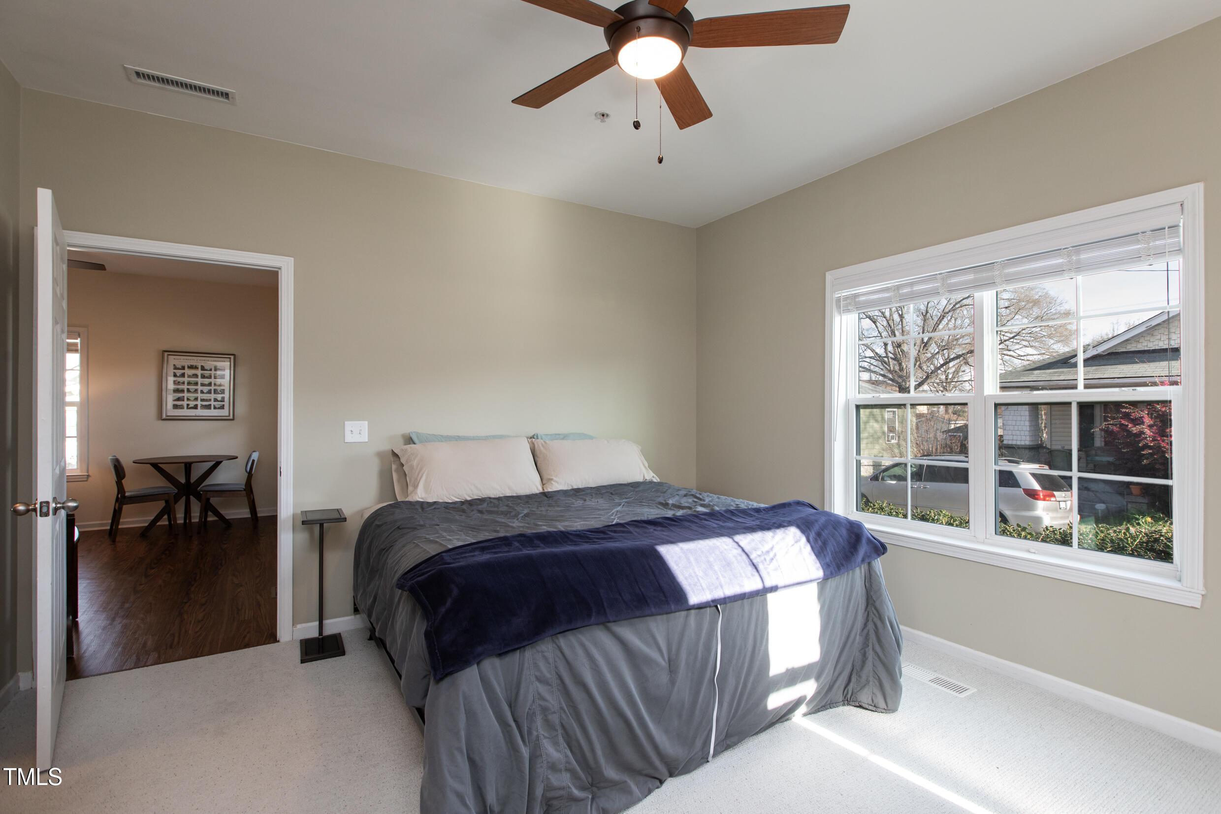 1208 Wall Street Durham, NC 27701 - Photo 10 of 16 a bedroom with a large bed and a chandelier fan