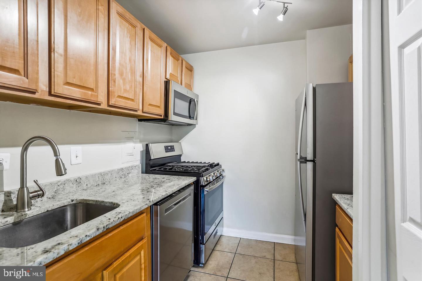 1900 Lyttonsville Road, Unit 602 Silver Spring, MD 20910 - Photo 21 of 43 a kitchen with stainless steel appliances granite countertop a sink stove and refrigerator