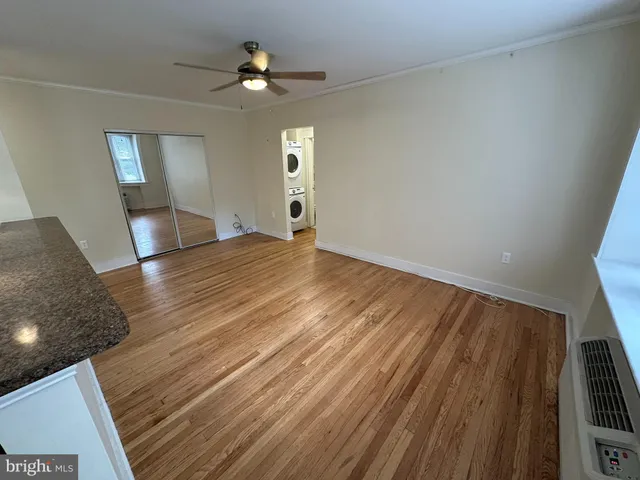 a view of empty room with wooden floor