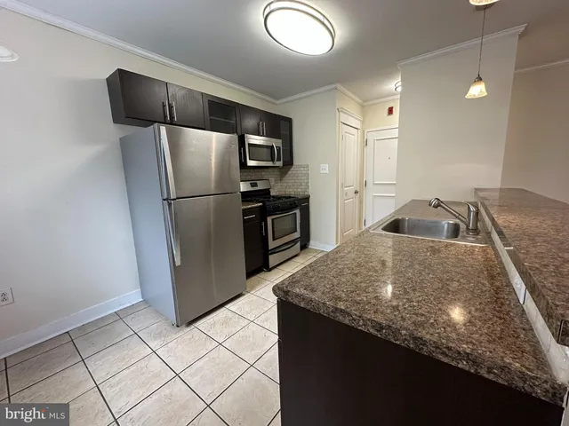 a kitchen with granite countertop a refrigerator and a sink