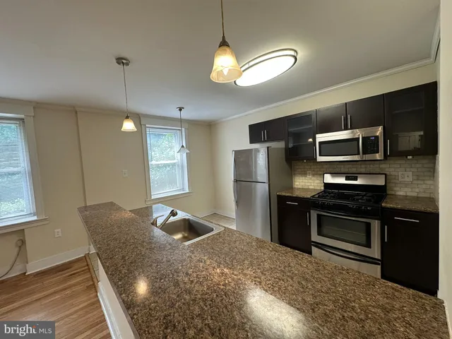 a kitchen with stainless steel appliances granite countertop a refrigerator a stove top oven a sink dishwasher and a refrigerator