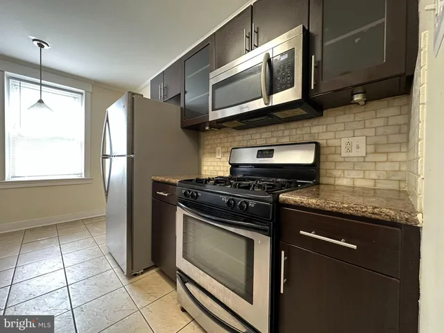 a kitchen with stainless steel appliances granite countertop a stove and a microwave