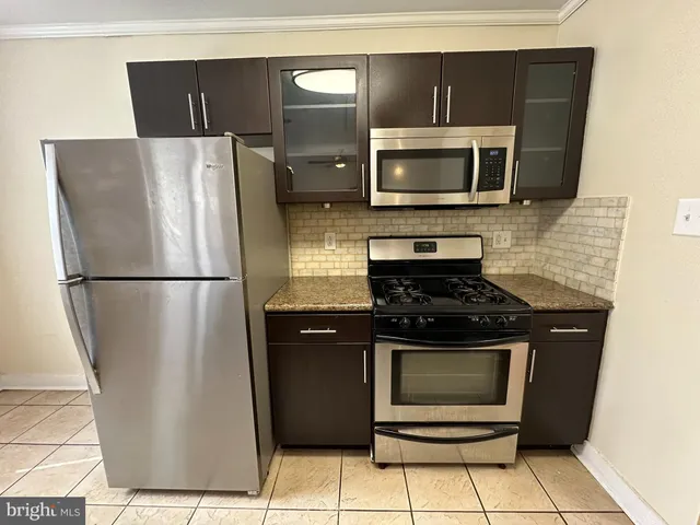 a kitchen with stainless steel appliances granite countertop a refrigerator stove and microwave