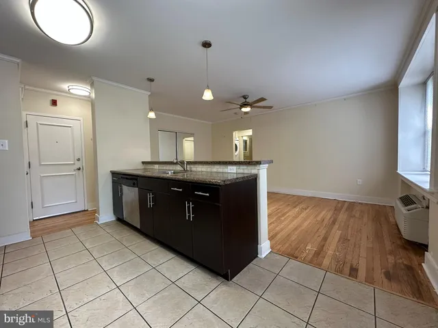 a kitchen with a sink a counter space and wooden floor