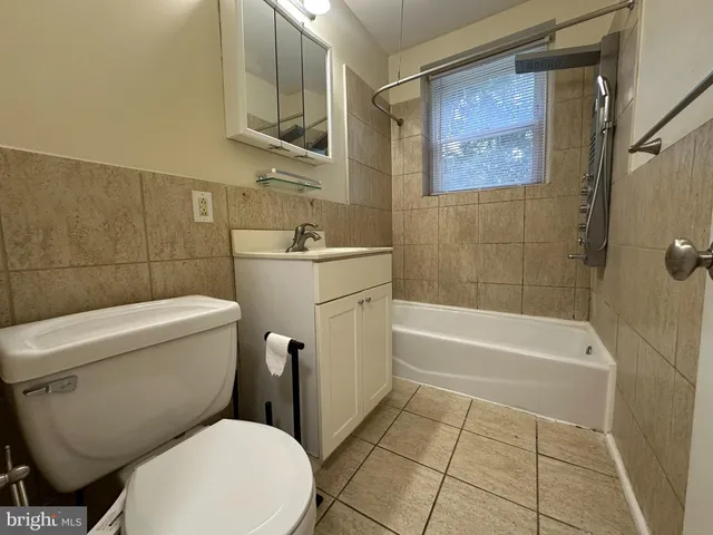 a white toilet sitting next to a bath tub and a shower