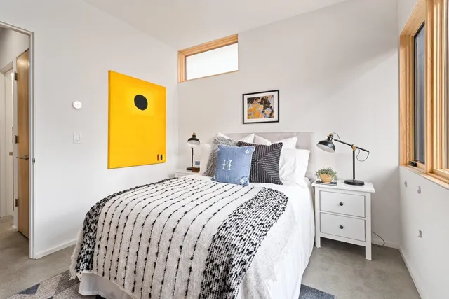 a bed sitting in a bedroom next to a window