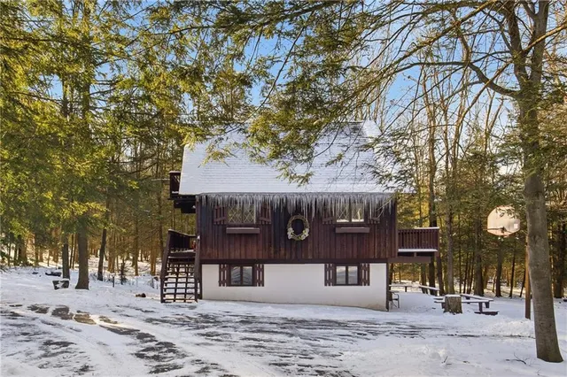 a front view of a house with a tree