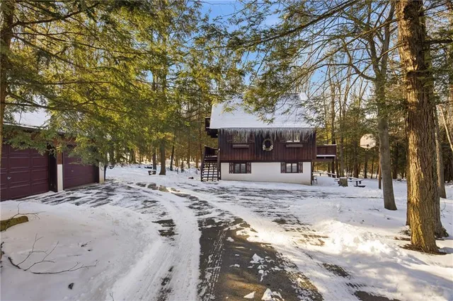 a view of a white house with a snow on the road