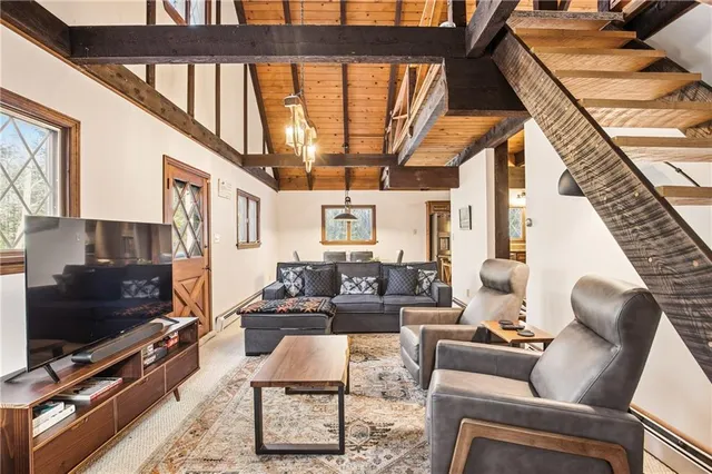 a living room with furniture a flat screen tv and a floor to ceiling window