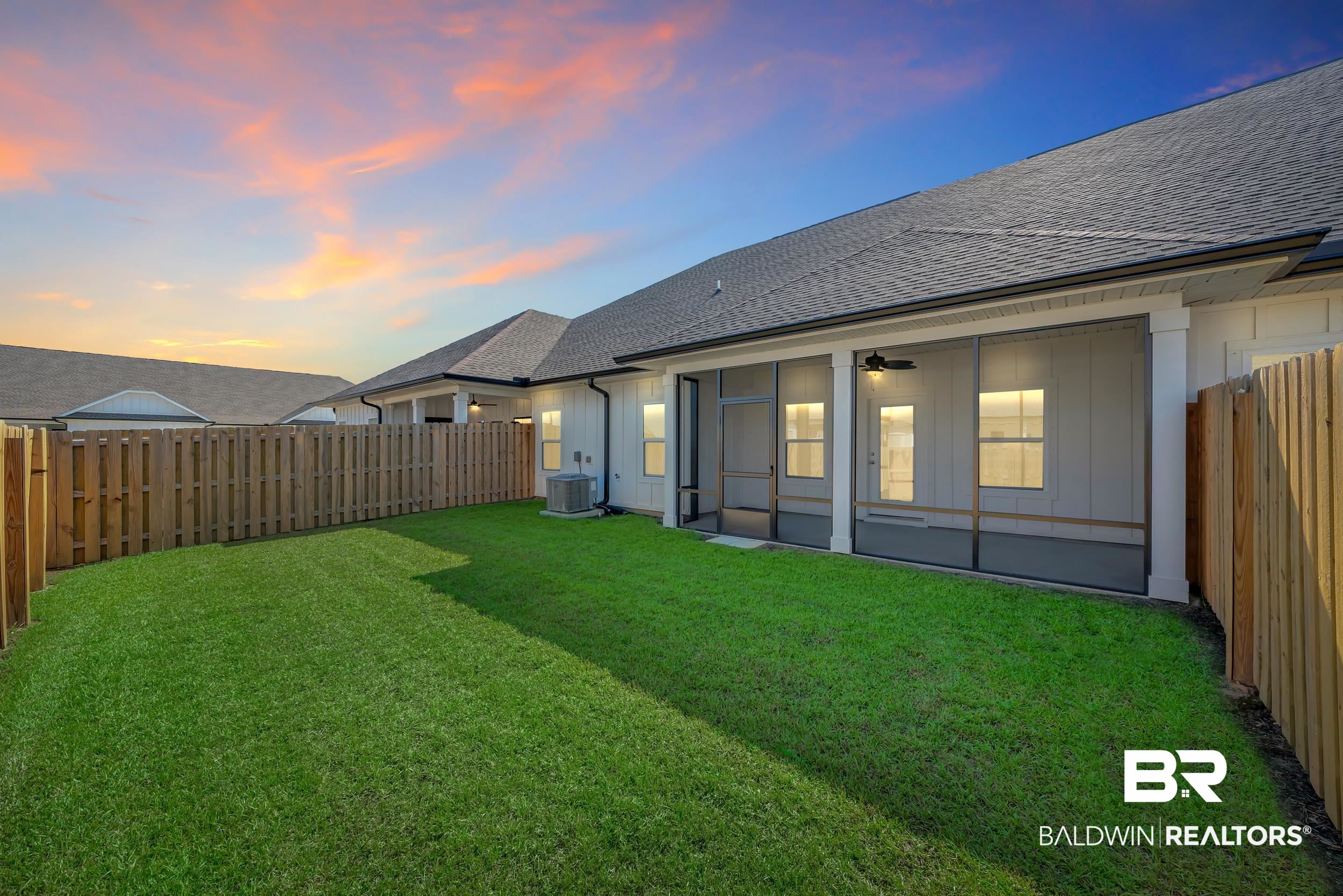 9933 Weller Cove Foley, AL 36535 - Photo 29 of 36 Expansive green lawn with a wood privacy fence