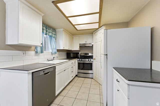 1052 South 950 East, Unit 33 Provo, UT 84606 - Photo 5 of 12 Kitchen featuring stainless steel appliances, white cabinetry, dark countertops, and light tile patterned flooring