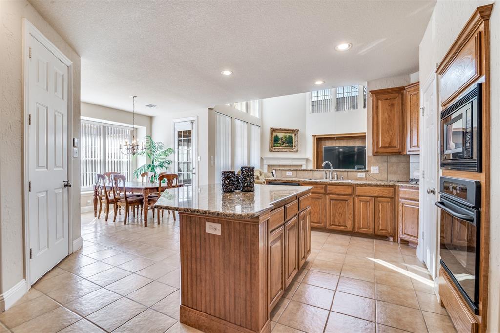 1113 Waterford Way Allen, TX 75013 - Photo 11 of 36 a kitchen with stainless steel appliances granite countertop a stove top oven a sink a counter top space and cabinets
