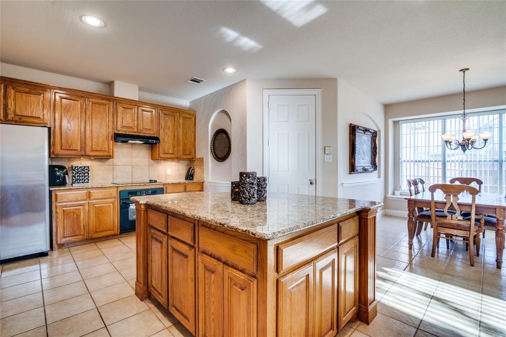 1113 Waterford Way Allen, TX 75013 - Photo 12 of 36 a kitchen with stainless steel appliances granite countertop a stove top oven a sink dishwasher and white cabinets with wooden floor