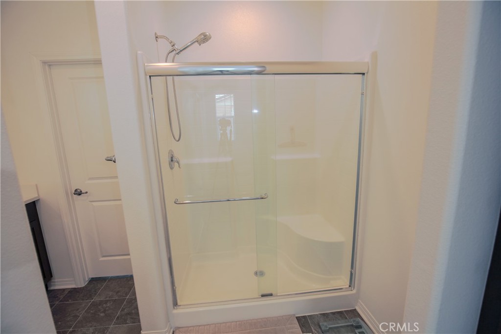 8529 Exposition Street Chino, CA 91708 - Photo 14 of 42 a bathroom with a glass shower door