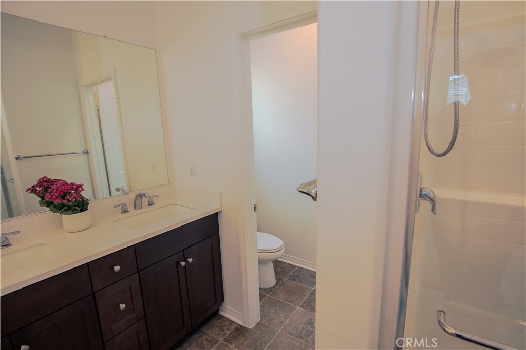 8529 Exposition Street Chino, CA 91708 - Photo 16 of 42 a bathroom with a double vanity sink toilet and a mirror