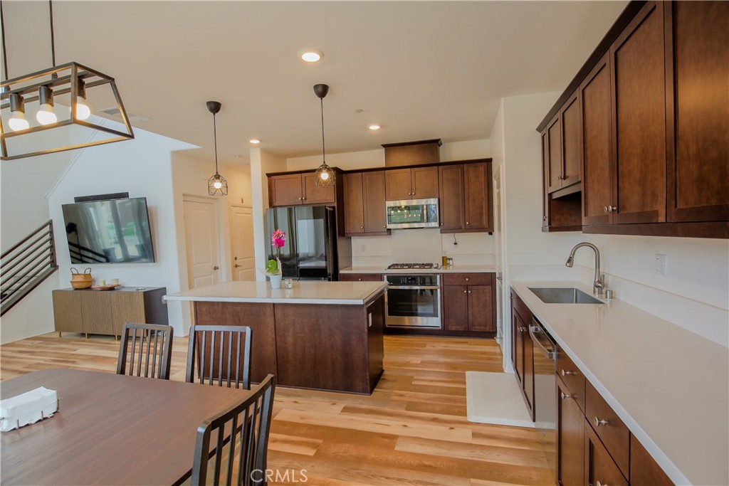 8529 Exposition Street Chino, CA 91708 - Photo 6 of 42 a kitchen with stainless steel appliances granite countertop a sink microwave and wooden cabinets