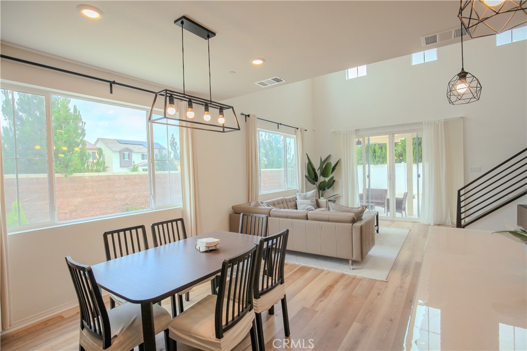 8529 Exposition Street Chino, CA 91708 - Photo 7 of 42 a dining room with wooden floor a chandelier a wooden table and chairs