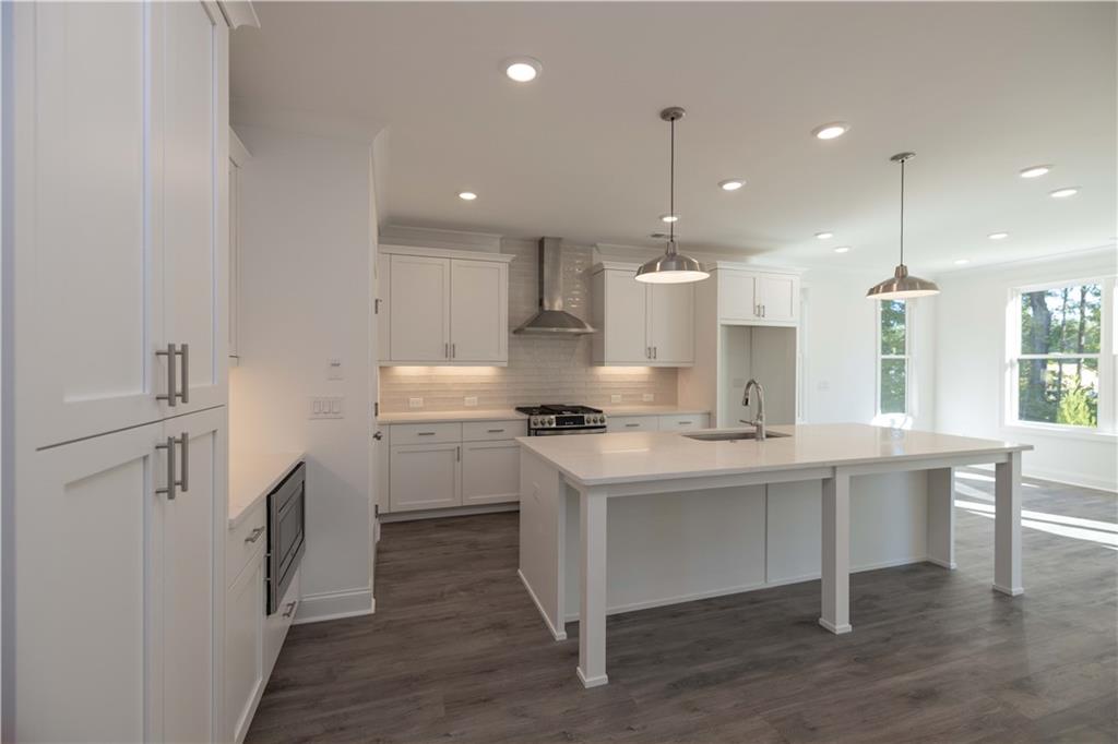 2240 Siskin Sq Road, Unit 88 Duluth, GA 30096 - Photo 16 of 42 a kitchen with kitchen island a sink stainless steel appliances and white cabinets