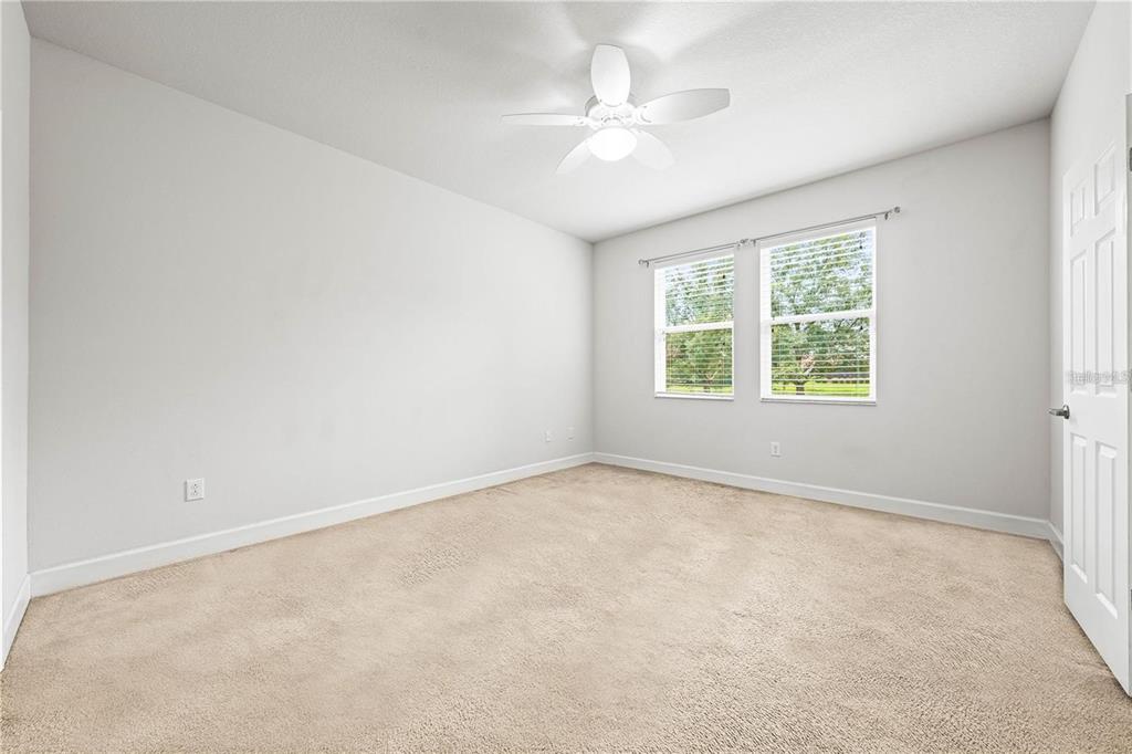 8437 Nandina Drive Sarasota, FL 34240 - Photo 13 of 26 an empty room with a chandelier fan and windows