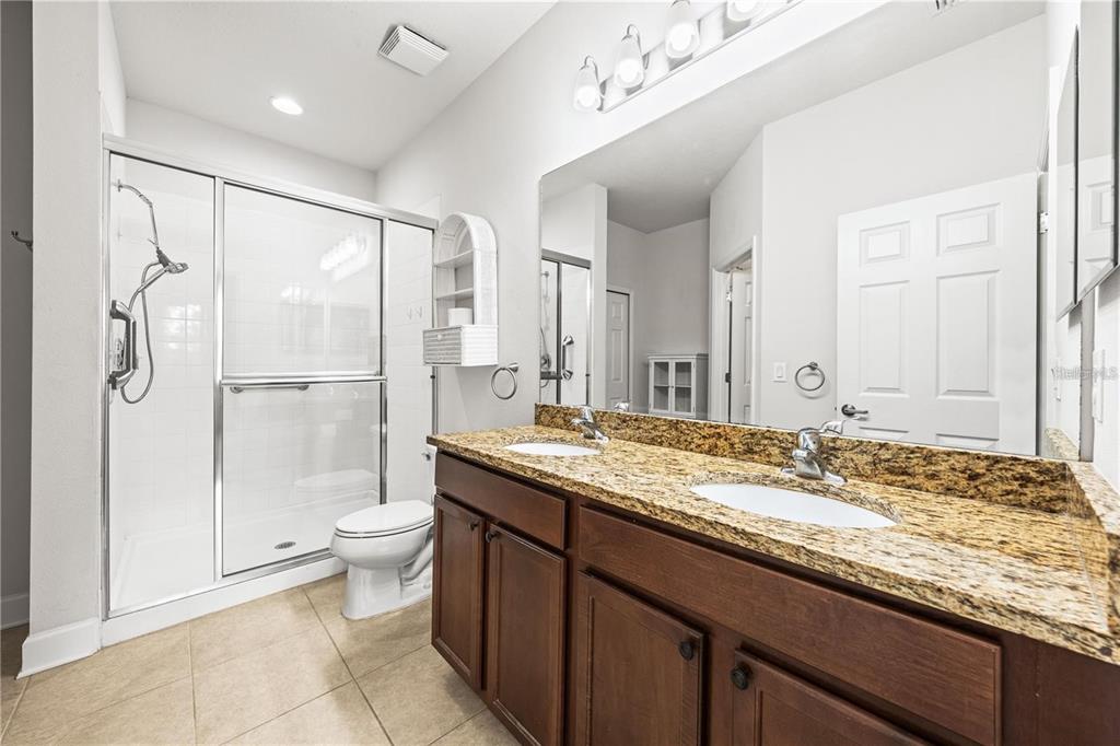 8437 Nandina Drive Sarasota, FL 34240 - Photo 15 of 26 a bathroom with a granite countertop sink toilet and shower