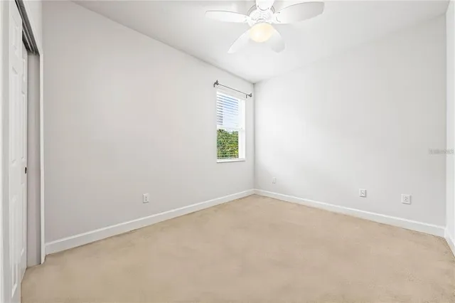 an empty room with a window and a fan