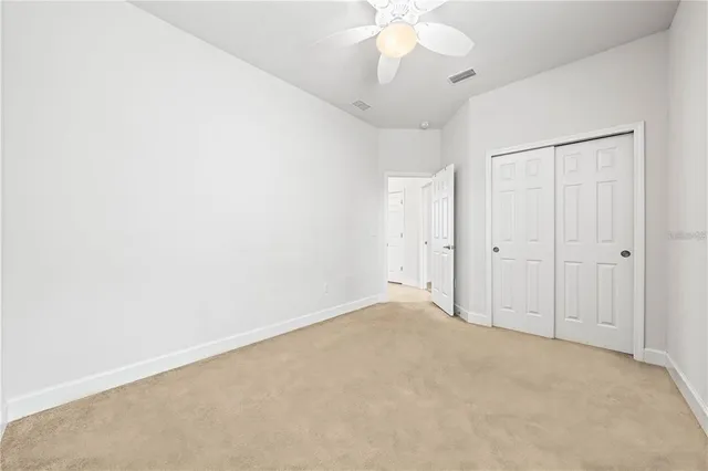 an empty room with a chandelier fan