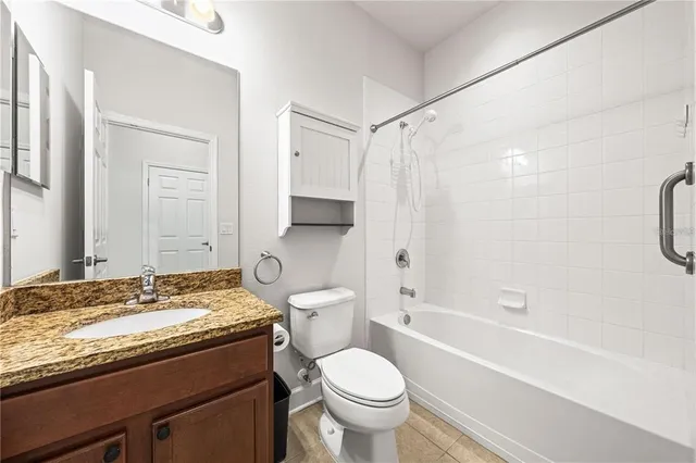 a bathroom with a granite countertop toilet sink and shower