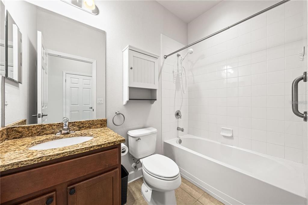 8437 Nandina Drive Sarasota, FL 34240 - Photo 20 of 26 a bathroom with a granite countertop toilet sink and shower