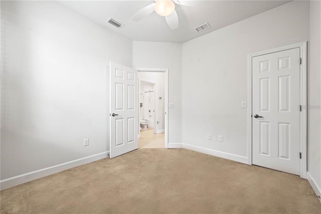 8437 Nandina Drive Sarasota, FL 34240 - Photo 22 of 26 an empty room with a ceiling fan and bathroom view