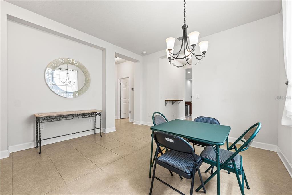 8437 Nandina Drive Sarasota, FL 34240 - Photo 6 of 26 a view of a dining room with furniture a chandelier and wooden floor