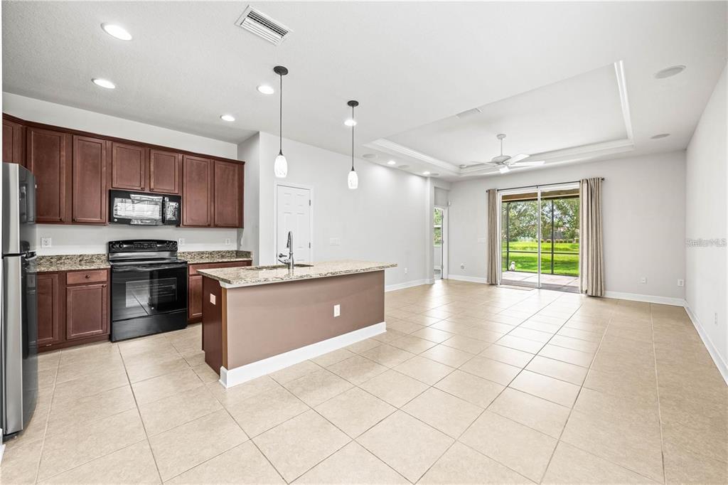 8437 Nandina Drive Sarasota, FL 34240 - Photo 8 of 26 a large kitchen with kitchen island granite countertop a stove a sink a counter top space and cabinets