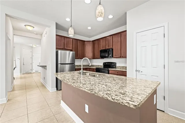 a kitchen with stainless steel appliances granite countertop a sink refrigerator and cabinets