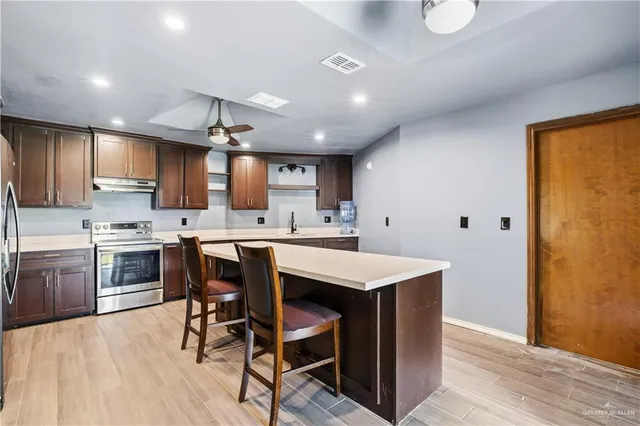 a kitchen with a table chairs refrigerator microwave and cabinets