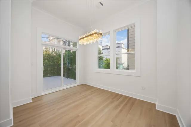 a view of a big room with wooden floor and windows